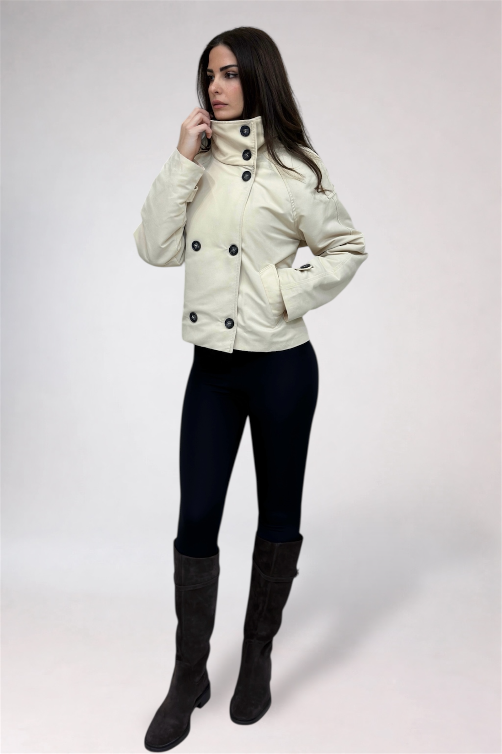 Woman wearing a white jacket with black buttons on a white background