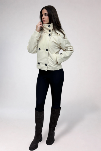 Woman wearing a white jacket with black buttons on a white background