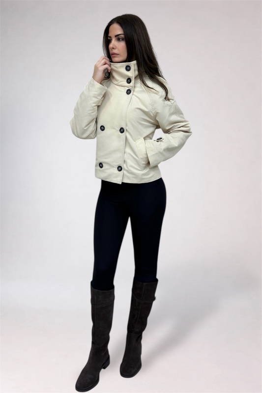 Woman wearing a white jacket with black buttons on a white background