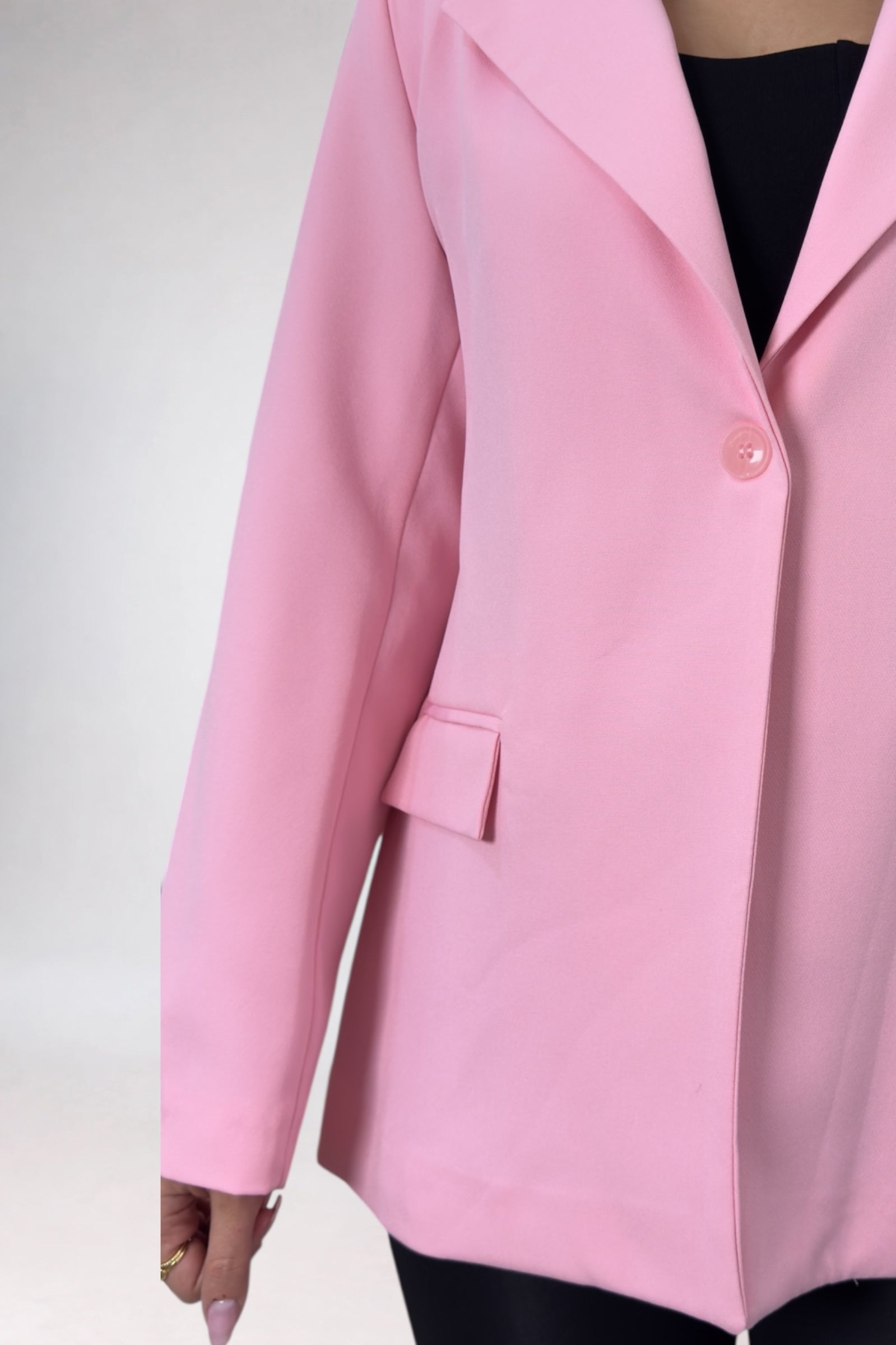 Pink blazer worn by a person on a white background