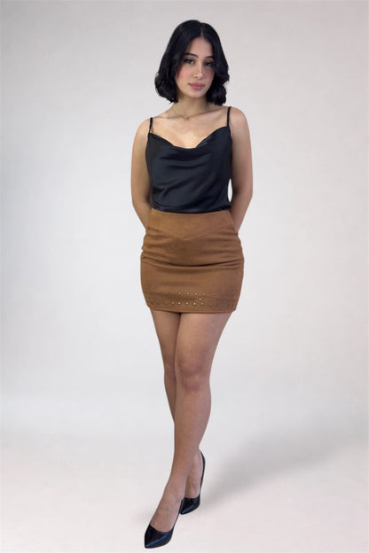 Woman wearing a black top and brown skirt on a white background