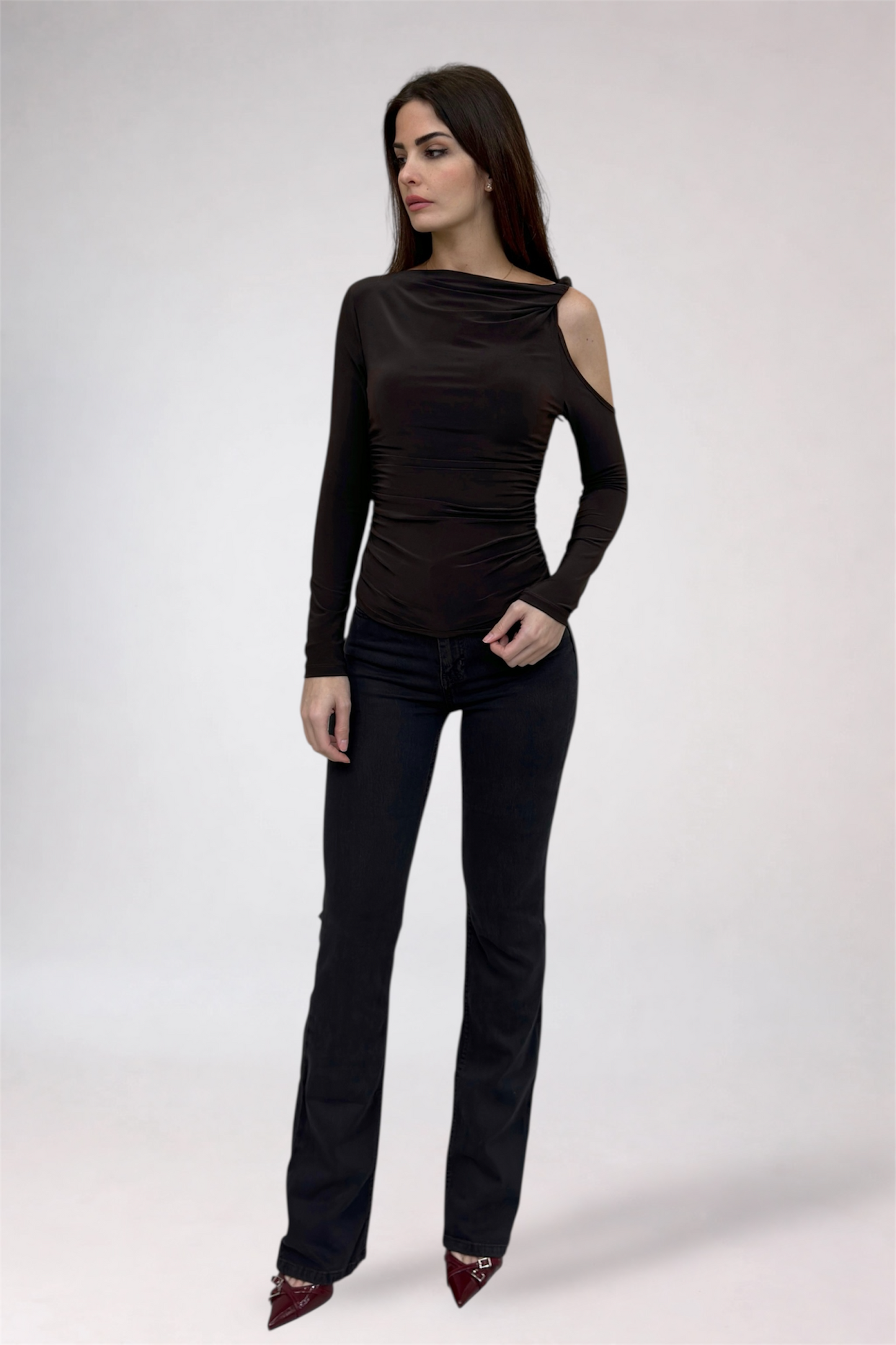 Woman wearing a black long-sleeve top and black pants on a white background