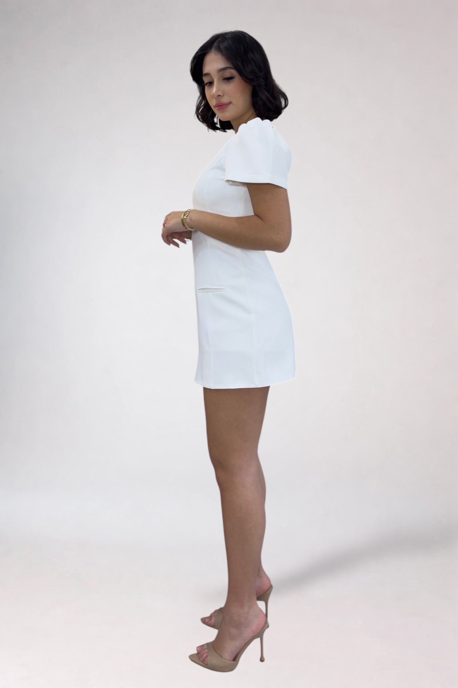 Woman wearing a white dress on a plain background