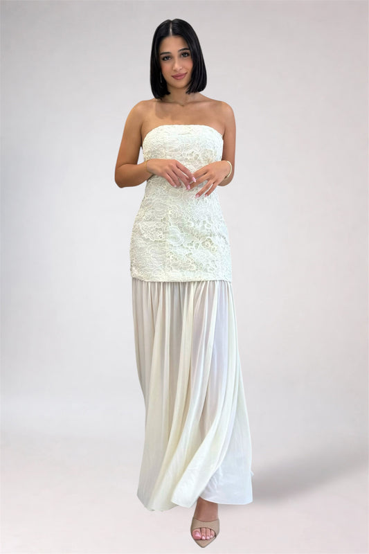 Woman wearing a strapless white dress with a plain background