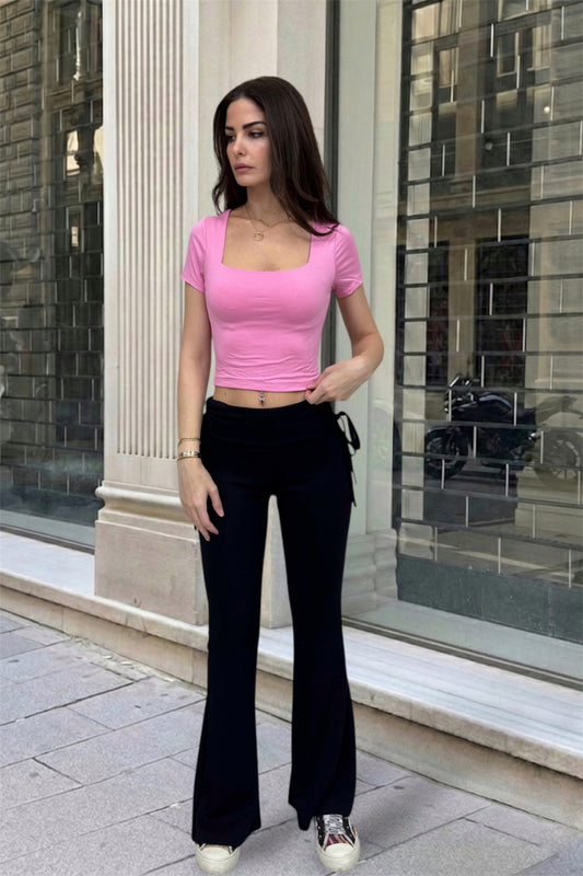 Women wearing pink top and black pants in the street