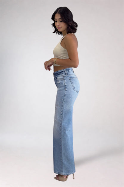 Woman wearing light blue jeans and a beige top on a white background