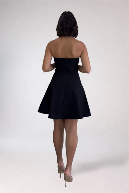 Woman wearing a black strapless dress on a white background