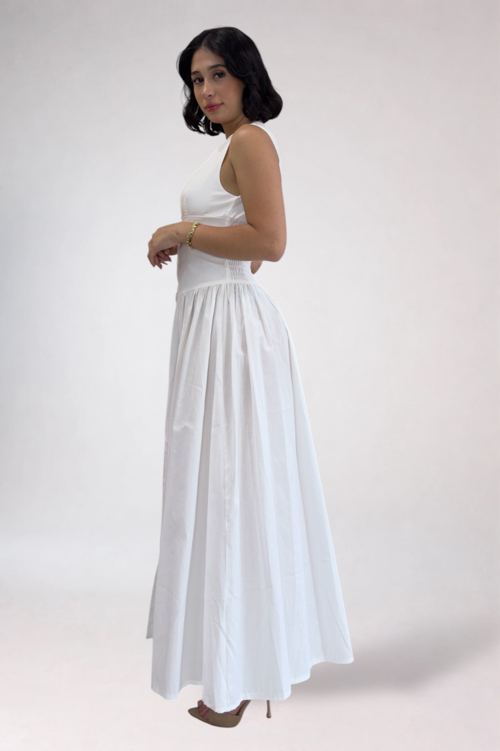 Woman wearing a white strapless dress on a plain background