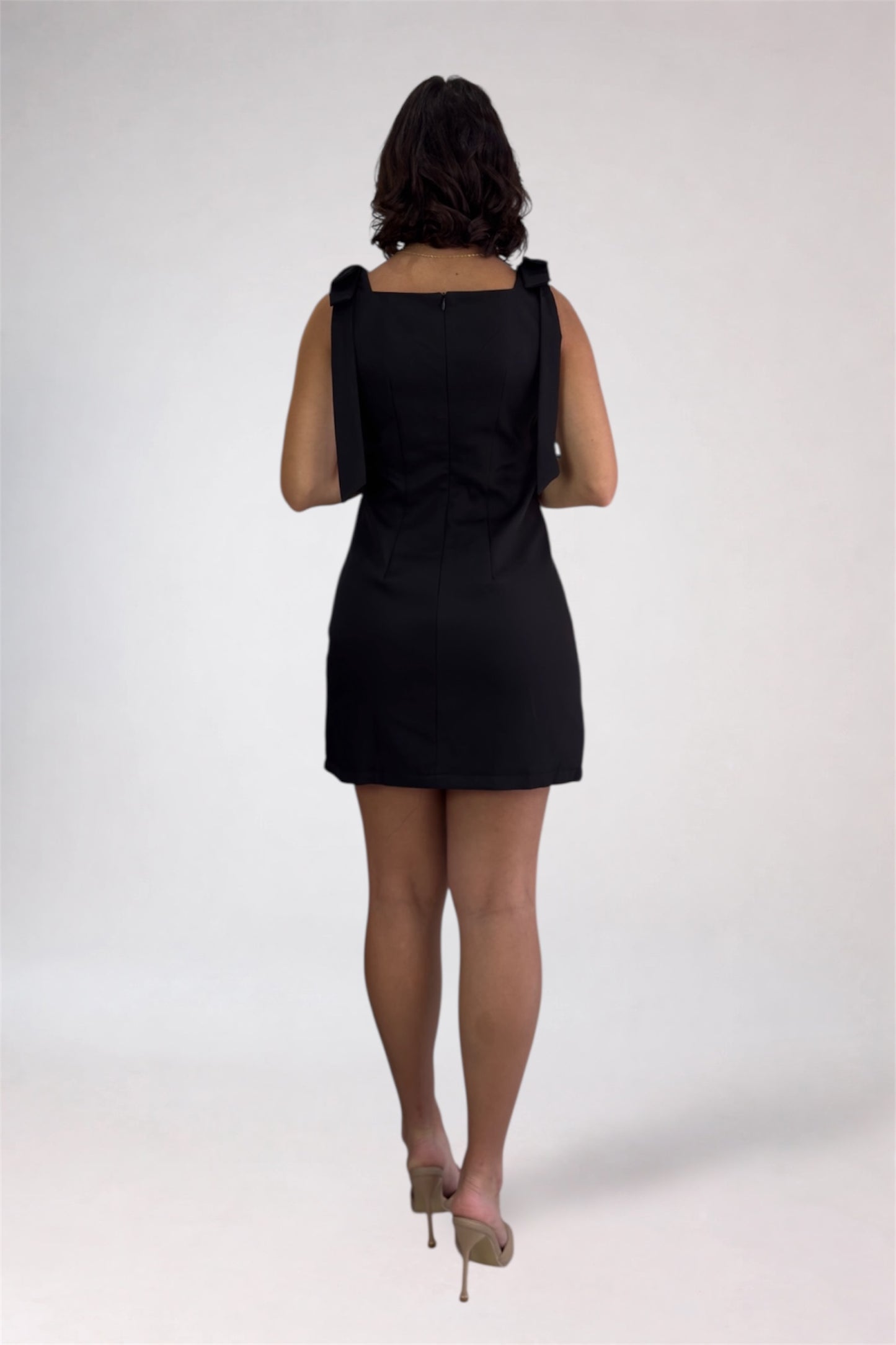 Person wearing a black dress on a white background