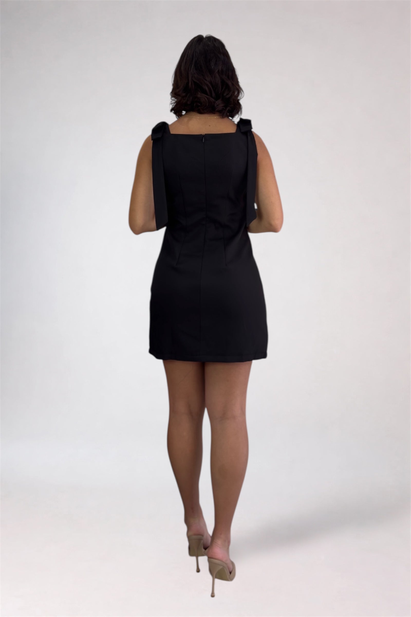 Person wearing a black dress on a white background