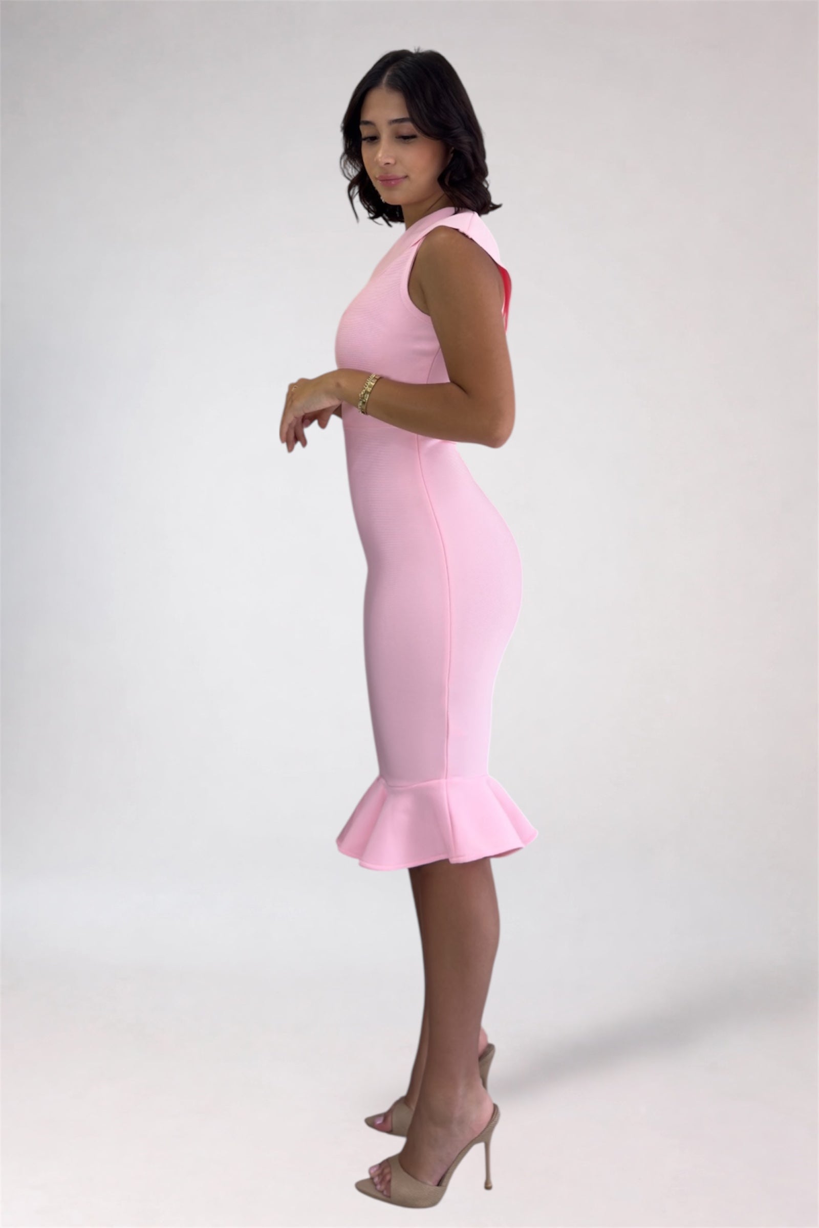 Woman wearing a pink dress with a plain background