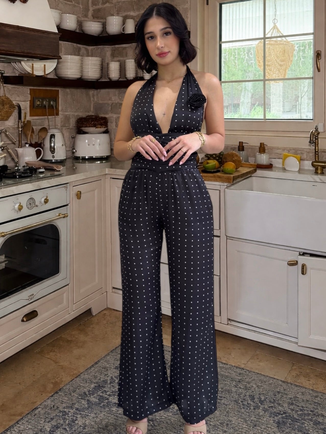 Woman in a navy blue jumpsuit standing in a kitchen.
