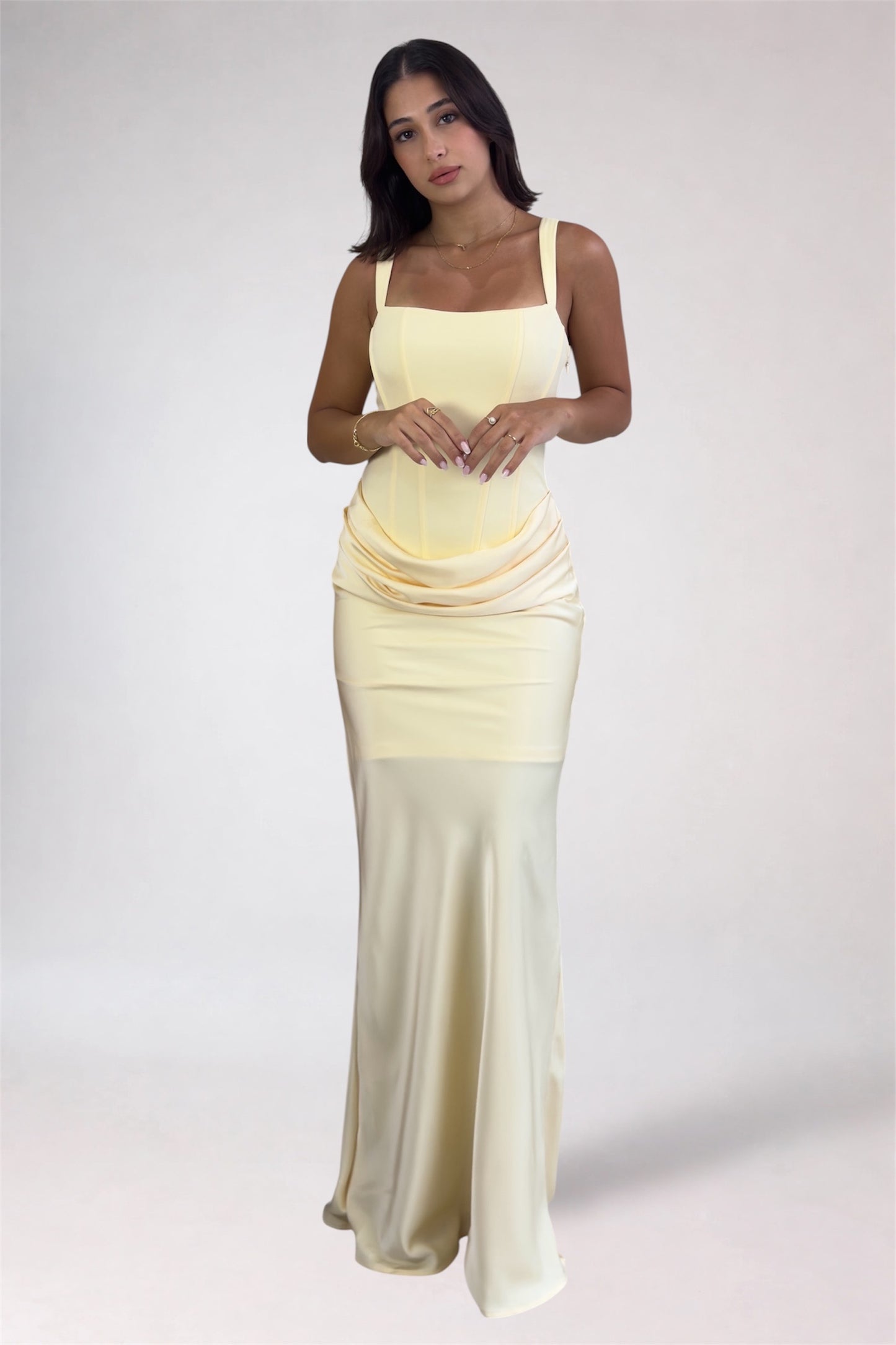 Woman wearing a yellow to white gradient dress on a white background