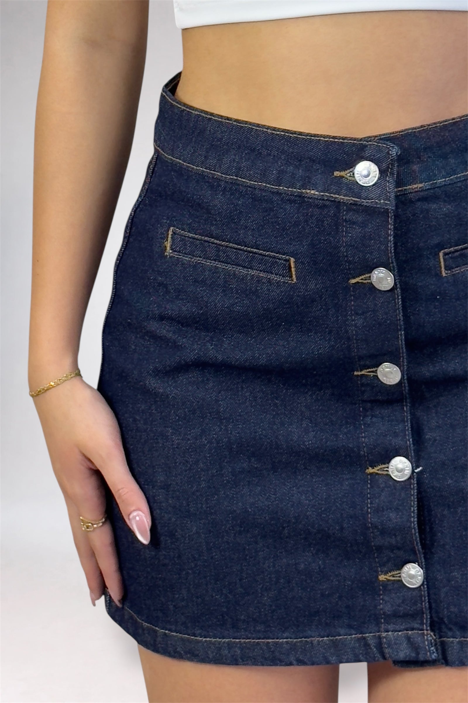 Denim skirt with button details on a plain background