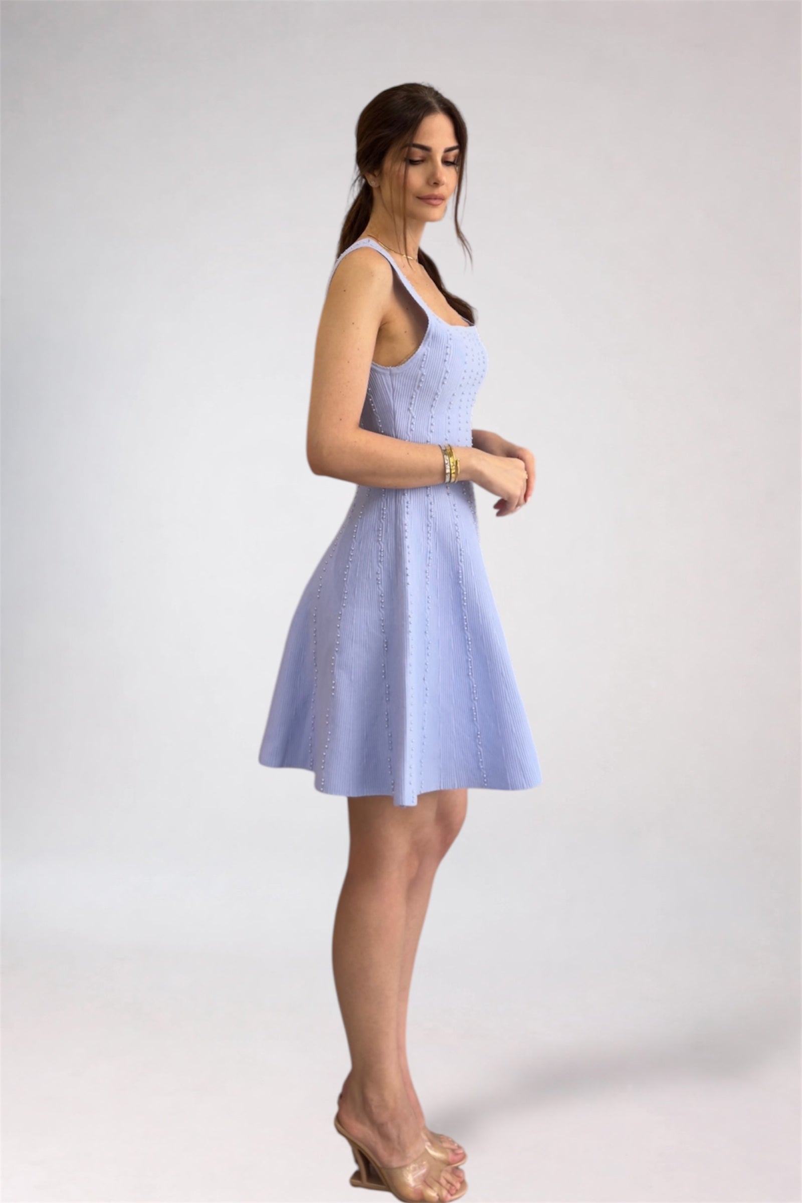 Woman wearing a light blue dress against a white background