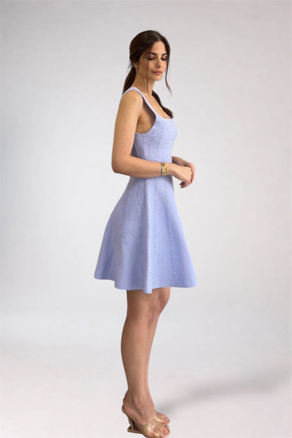 Woman wearing a light blue dress against a white background