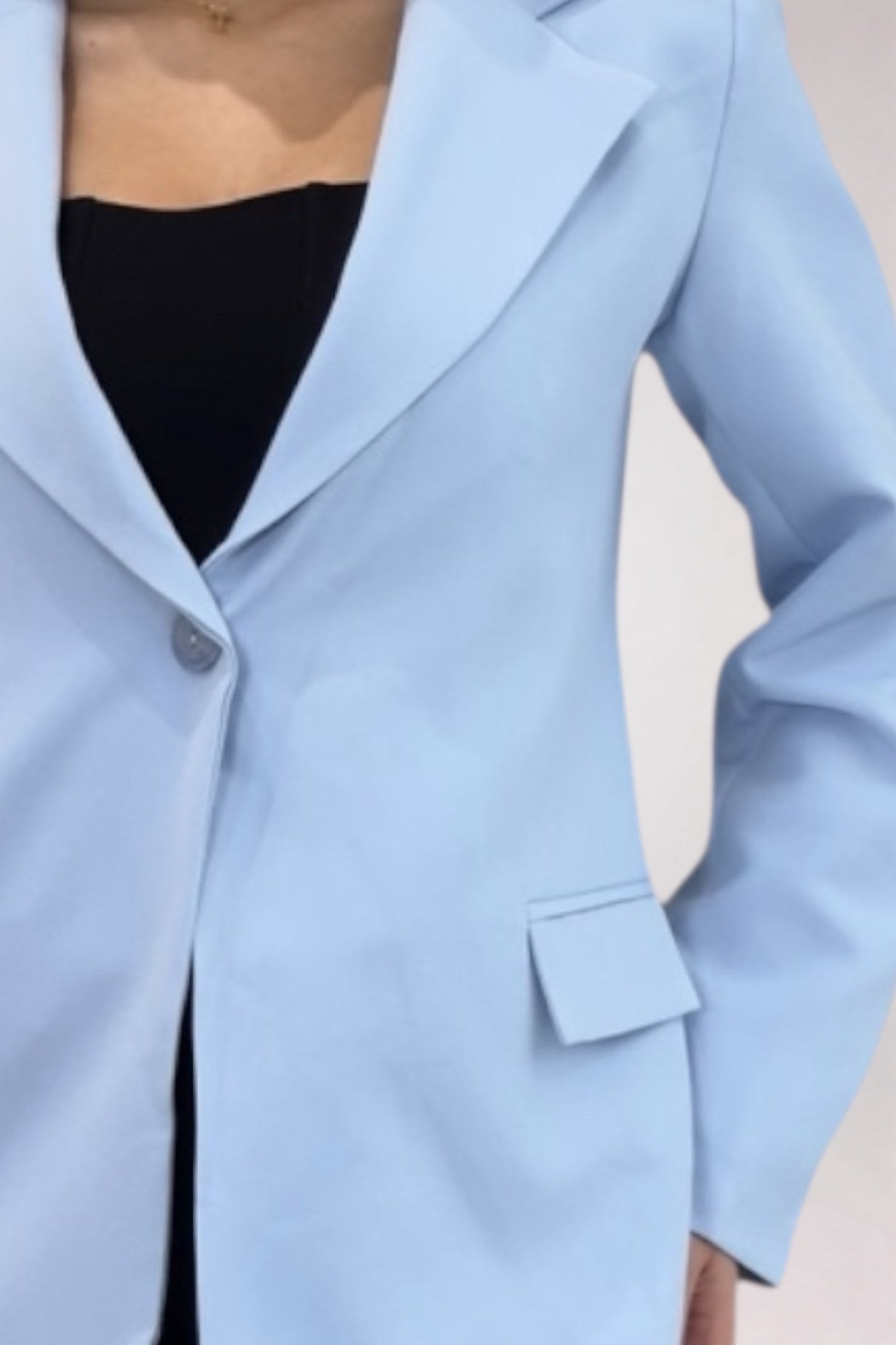 Light blue blazer worn by a person on a neutral background