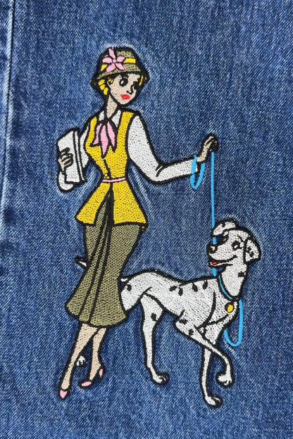 Embroidered design on denim fabric of a woman walking a Dalmatian dog.