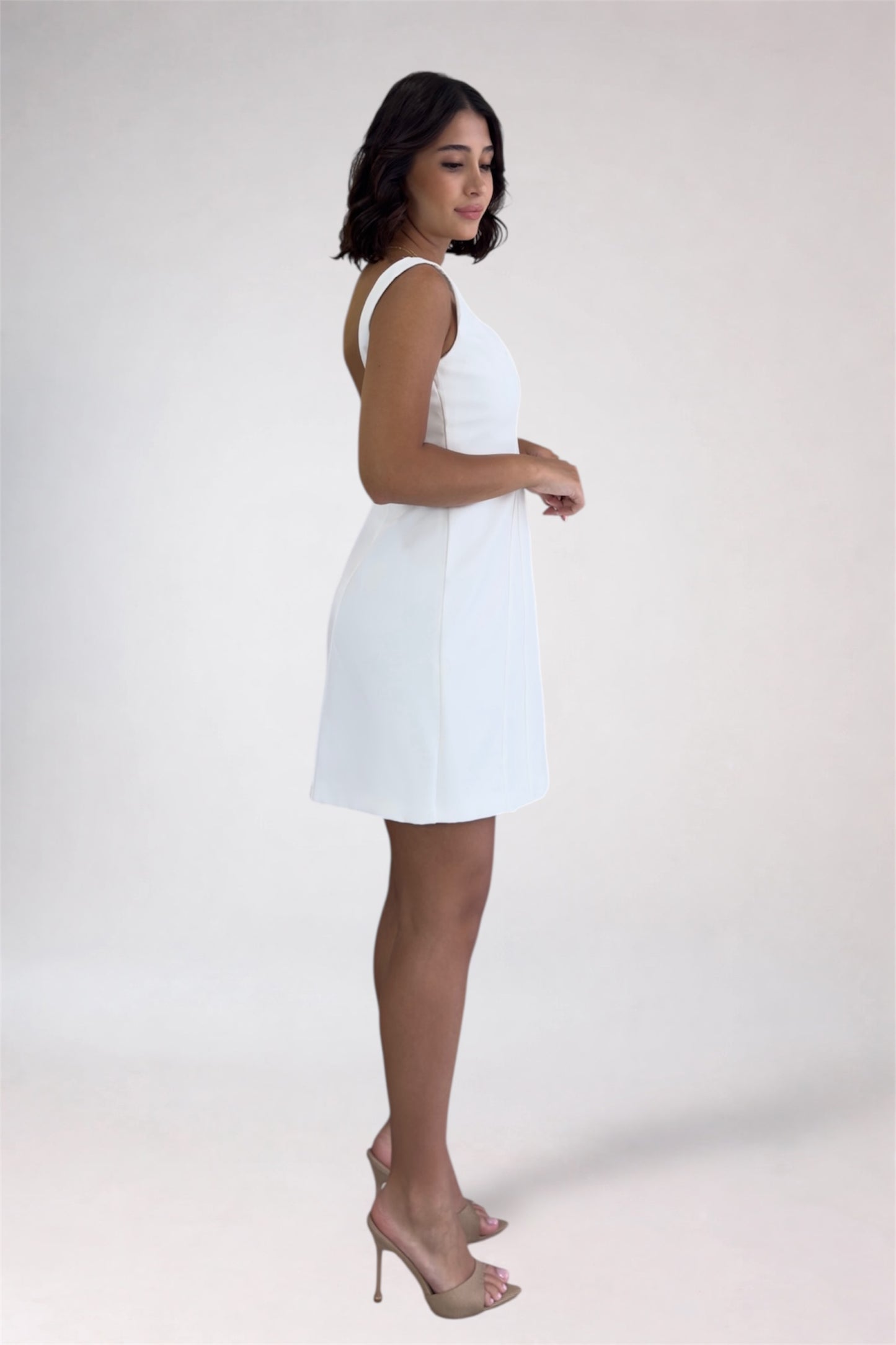 Woman wearing a white dress against a plain background