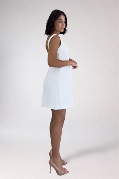 Woman wearing a white dress against a plain background