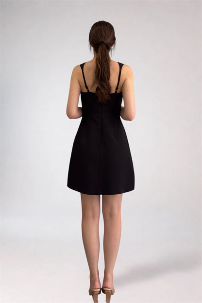 Woman wearing a black dress from behind on a white background