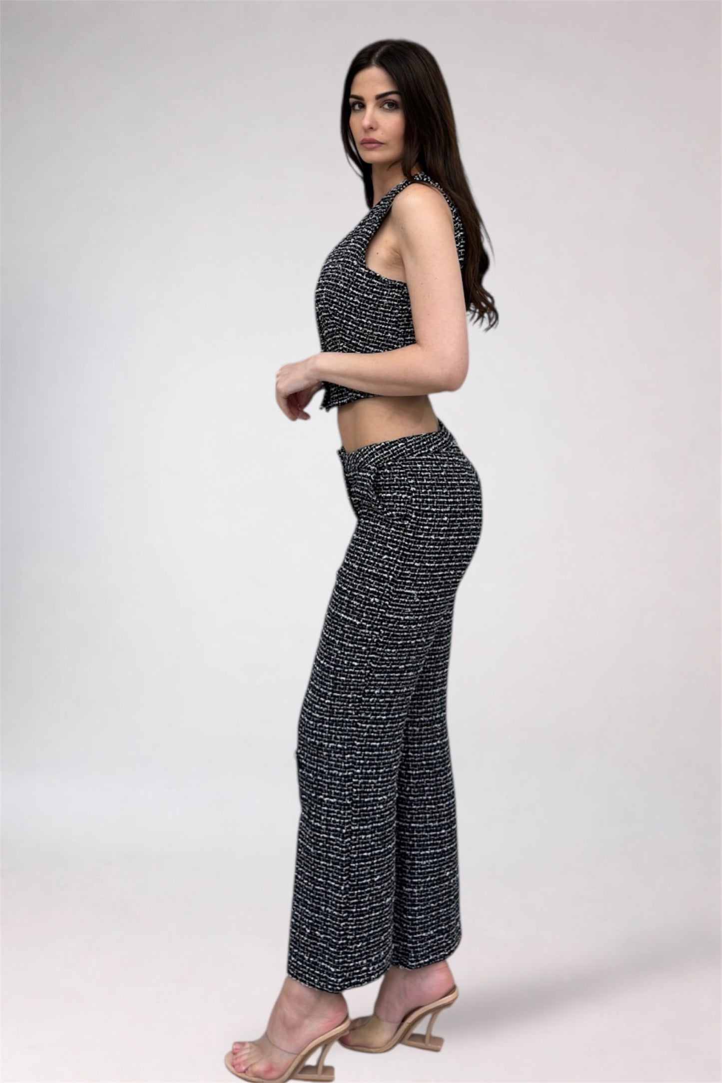Woman wearing a black and white patterned outfit on a plain background