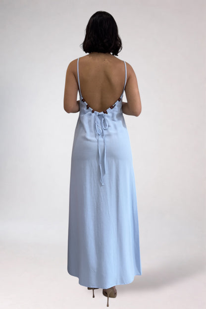 Woman wearing a light blue dress with lace details on a white background