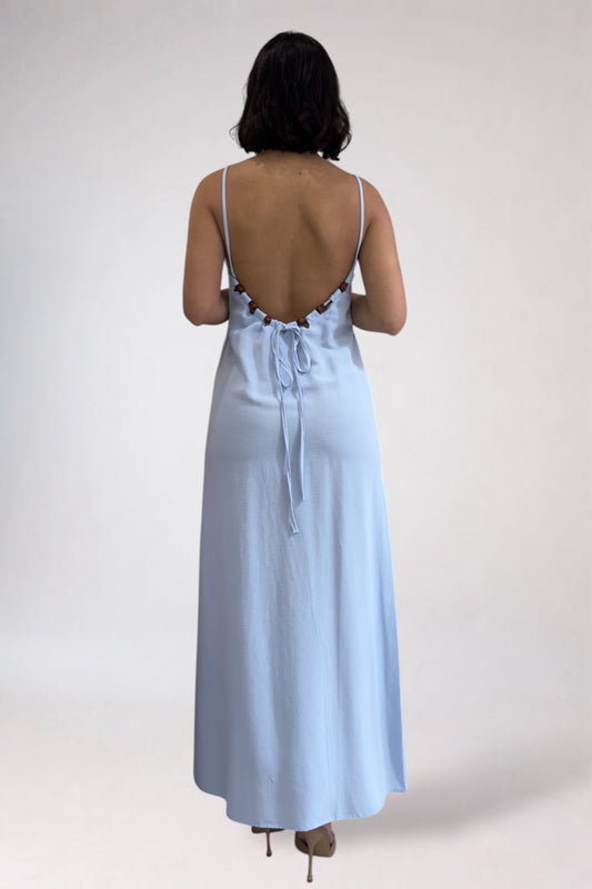 Woman wearing a light blue dress with lace details on a white background