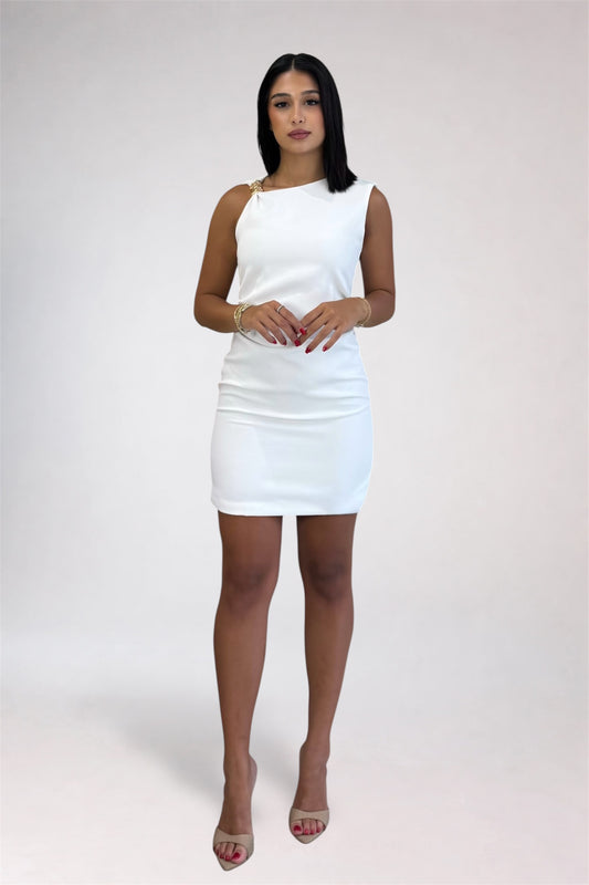 A woman modeling a white sleeveless bodycon mini dress with a single gold-tone ring detail at the shoulder, paired with nude high-heeled sandals, against a light gray studio background.