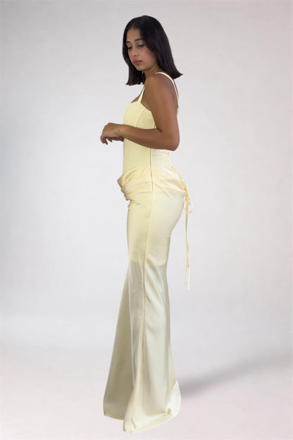 Woman wearing a light yellow jumpsuit on a white background
