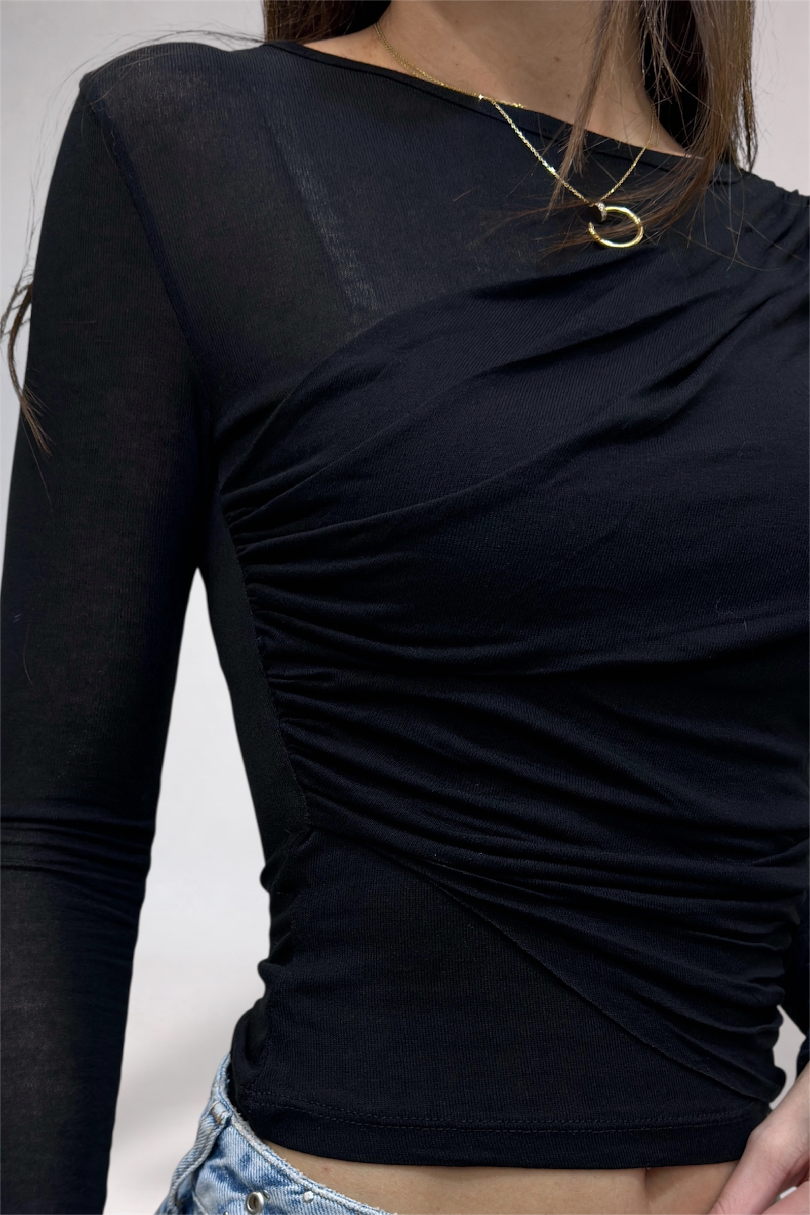 Black long-sleeve top with a draped design on a plain background