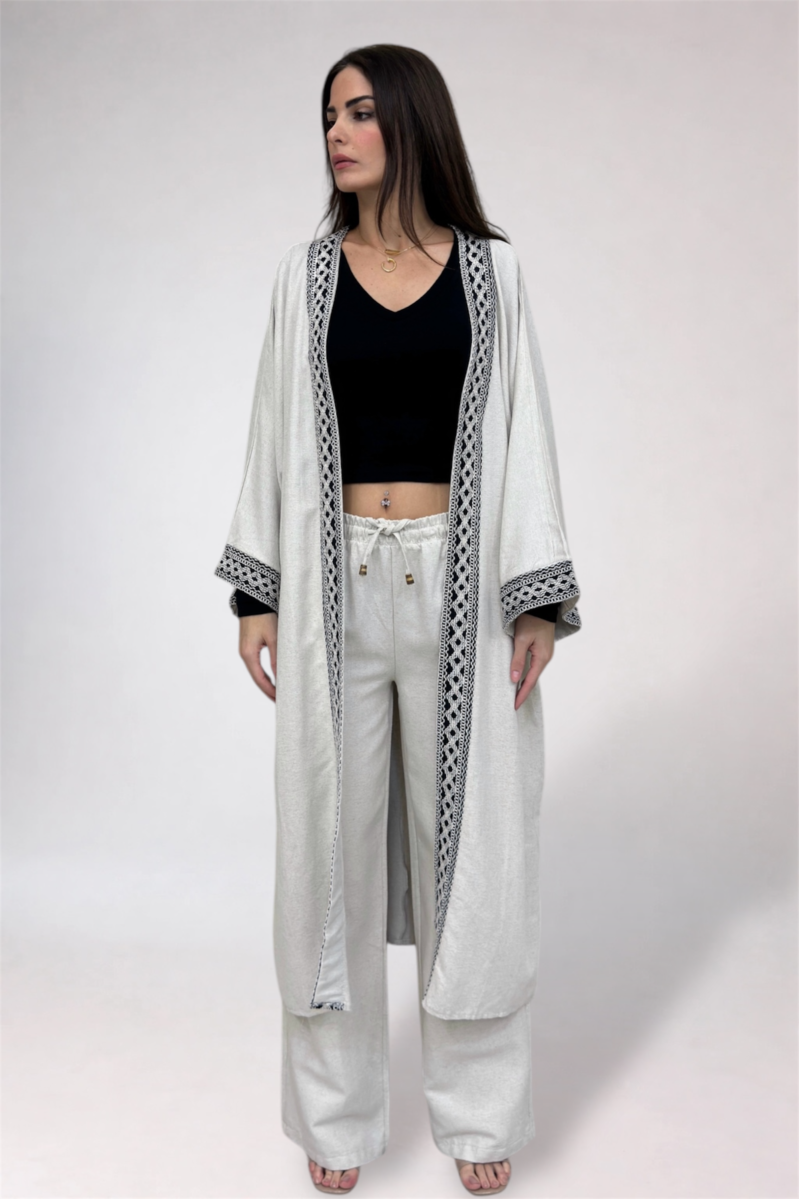 Woman wearing a long white robe with black patterns on a white background