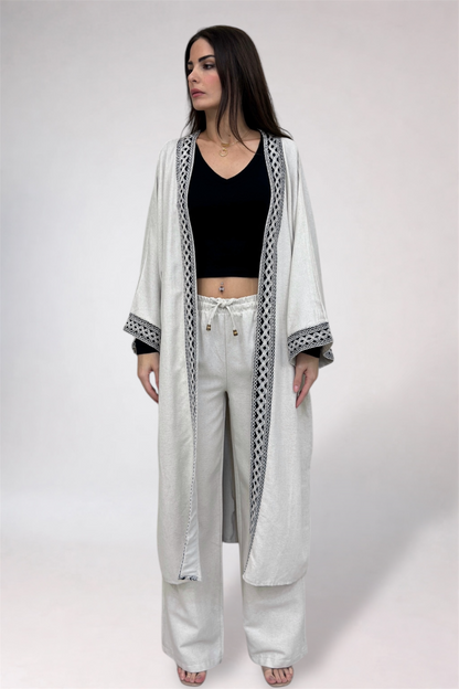 Woman wearing a long white robe with black patterns on a white background