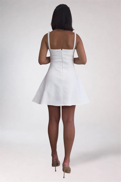 Person wearing a white dress on a plain background