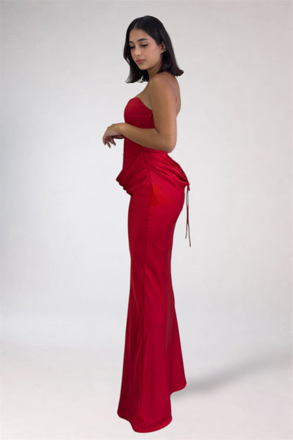 Woman wearing a red strapless gown on a white background