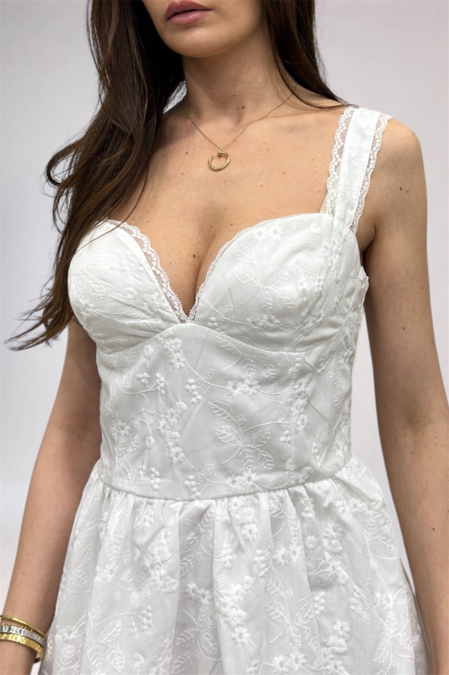 White floral dress worn by a person on a plain background