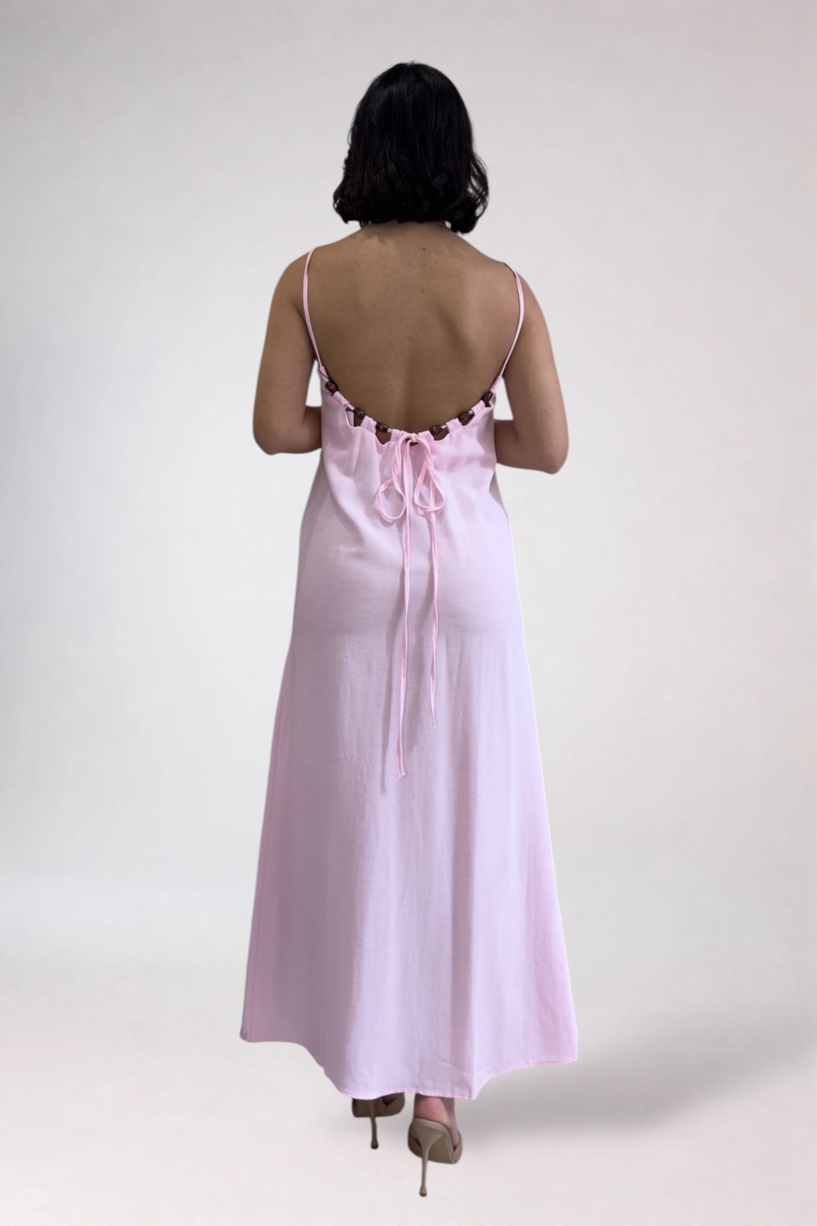 Woman wearing a pink satin nightgown on a white background