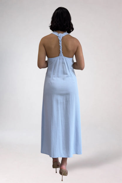 Woman wearing a light blue dress with a halter neck design on a white background