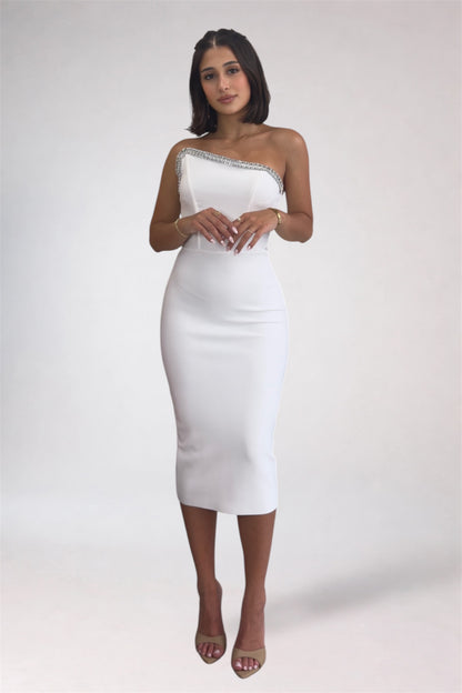 Woman wearing a white one-shoulder dress on a plain background