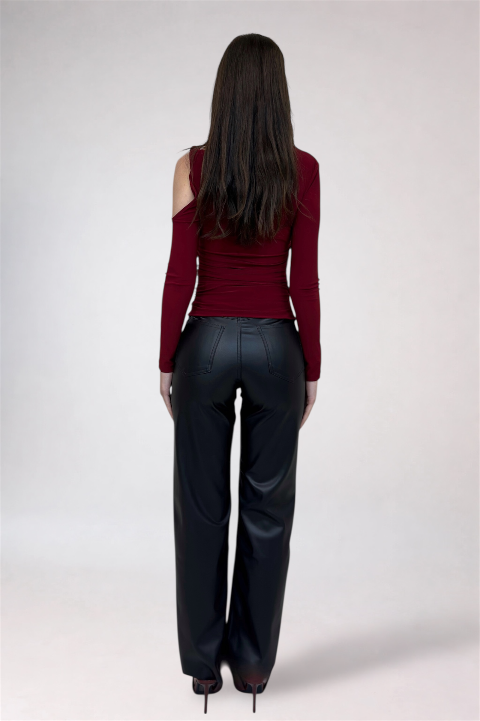 Woman wearing a red top and black pants on a white background