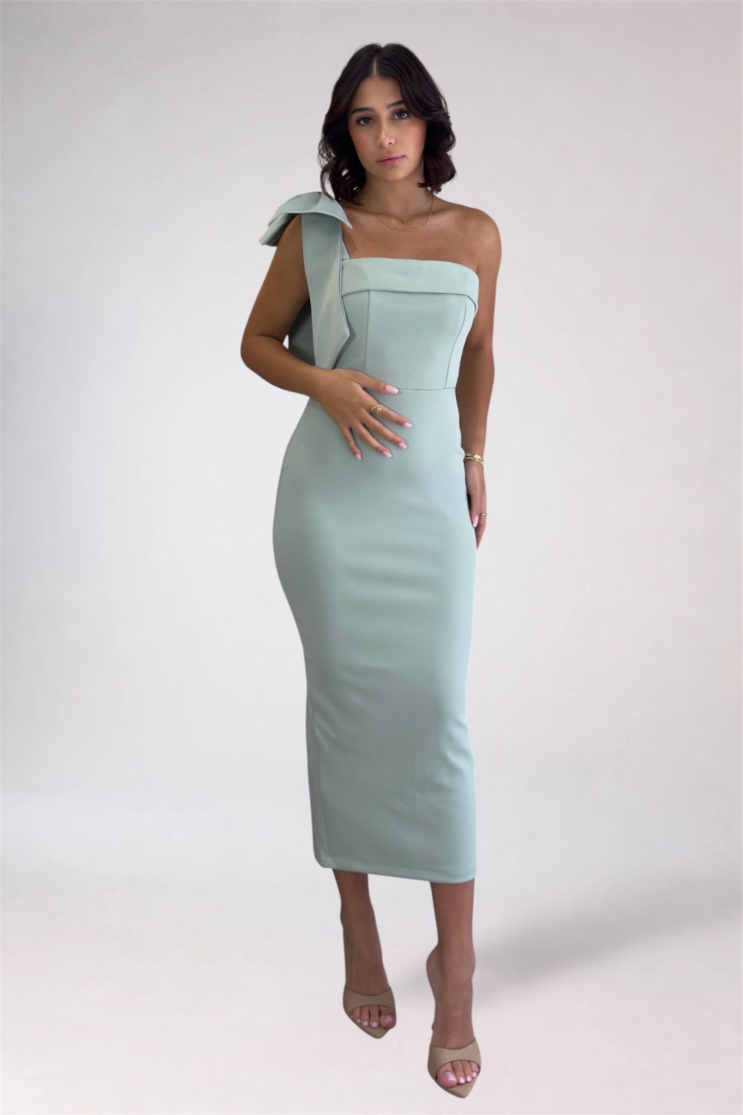 Woman wearing a light blue one-shoulder dress on a white background