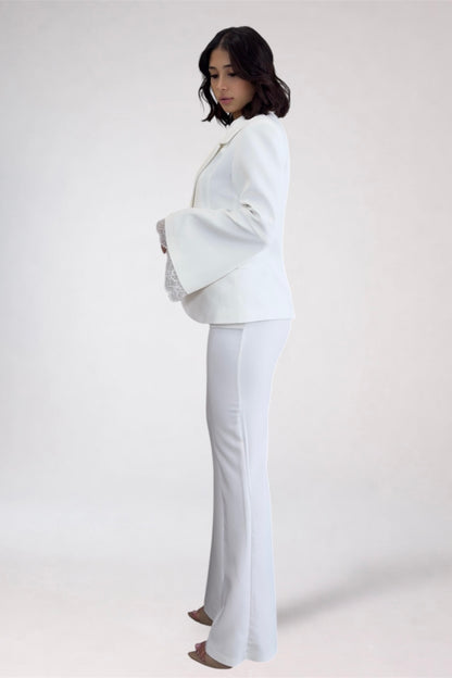 Woman wearing a white suit on a plain background