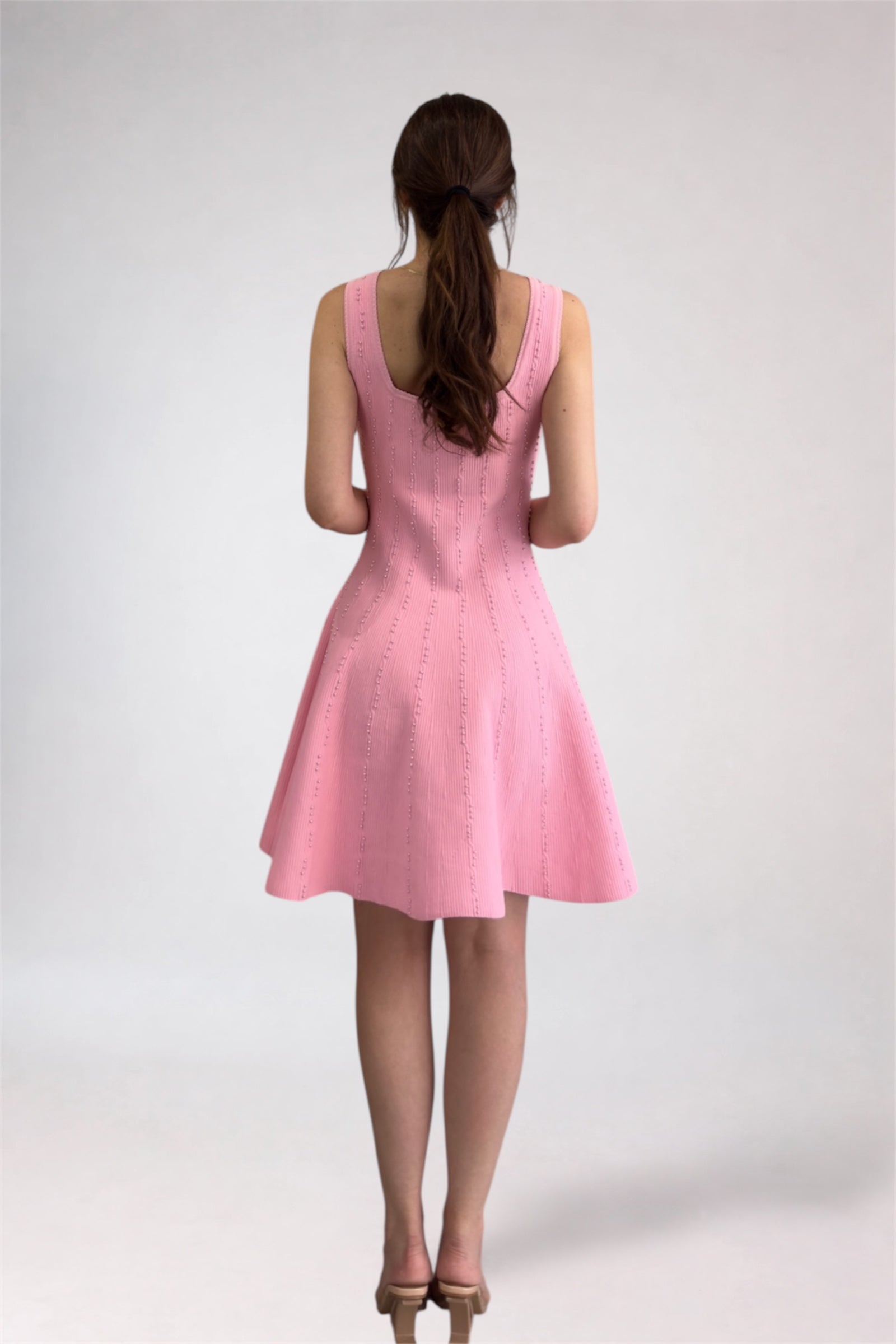 Pink dress worn by a person on a white background