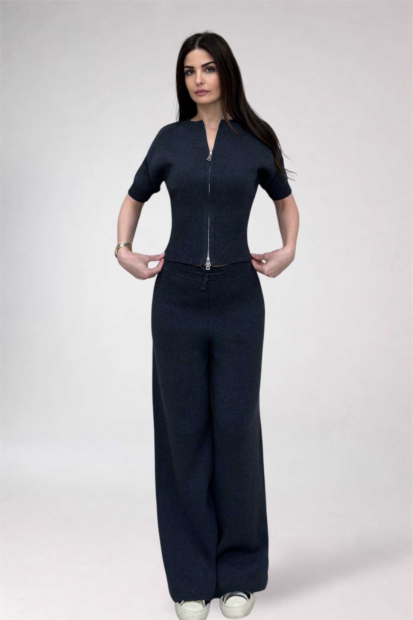 Woman wearing a black outfit with a zipper on a white background