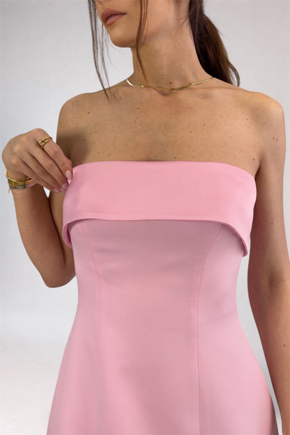 Pink strapless dress worn by a person on a plain background