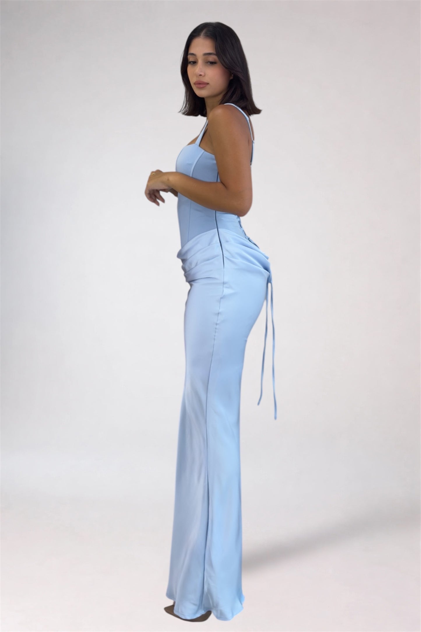 Woman wearing a light blue jumpsuit on a white background
