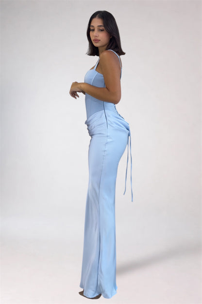 Woman wearing a light blue jumpsuit on a white background