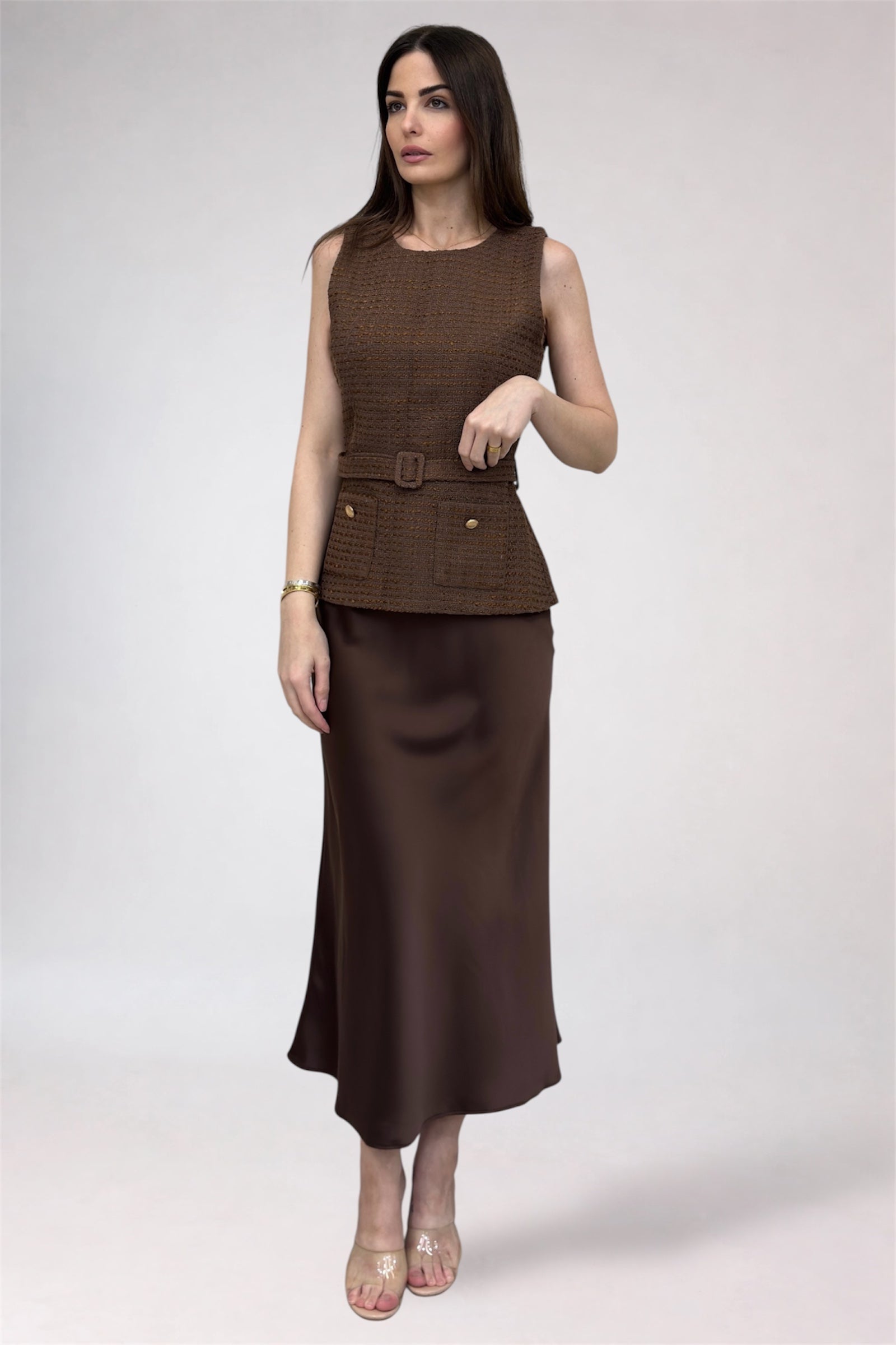 Woman wearing a brown dress with a belt on a white background