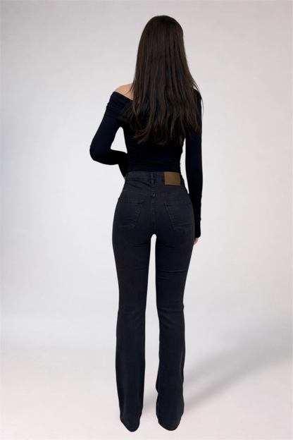 Person wearing black jeans and a black top on a white background