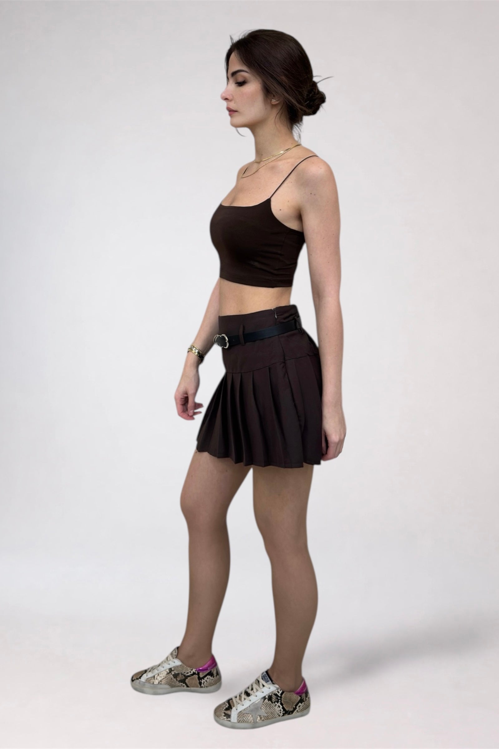 Woman wearing a black crop top and skirt on a white background